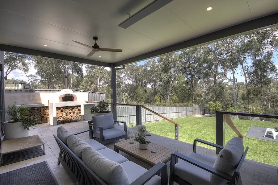 Insulated pergola over the lounge and wood-fired oven, opening to the lawn and bush