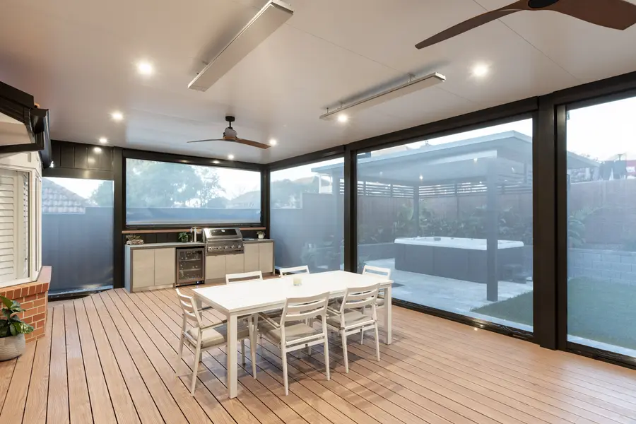 Inside the alfresco with the blinds closed — strip heaters, fans and the outdoor kitchen