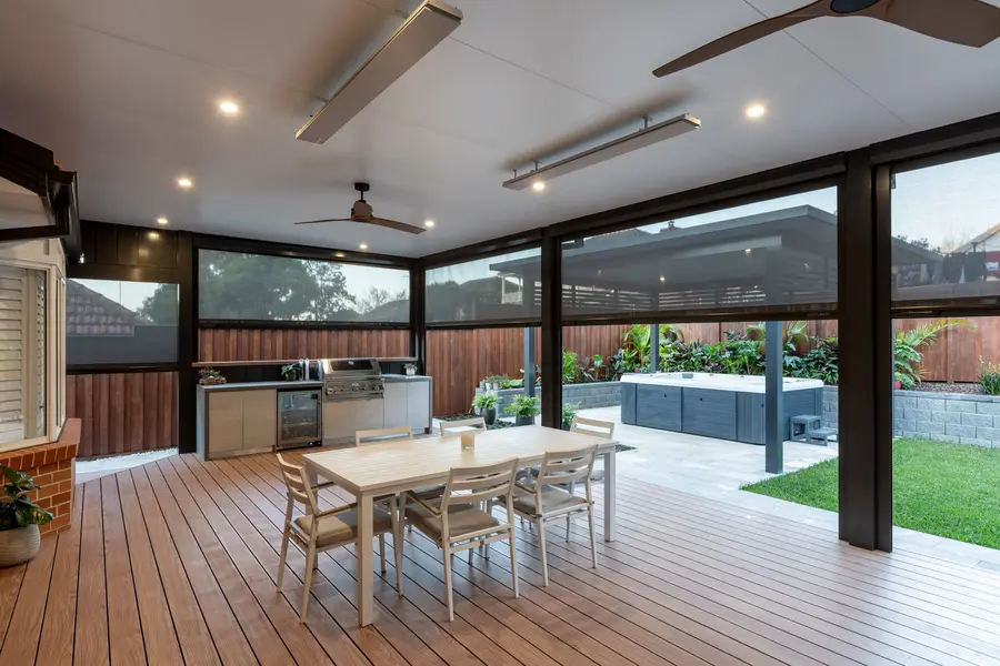 The enclosed alfresco lit at dusk, looking out to the spa through the blinds