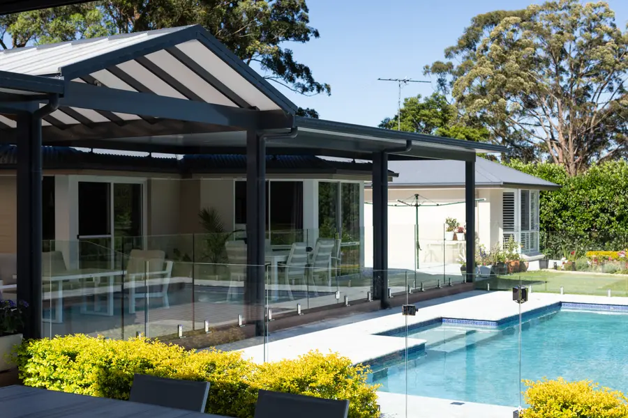 The polycarbonate gable meeting the insulated flat roof, seen from the pool