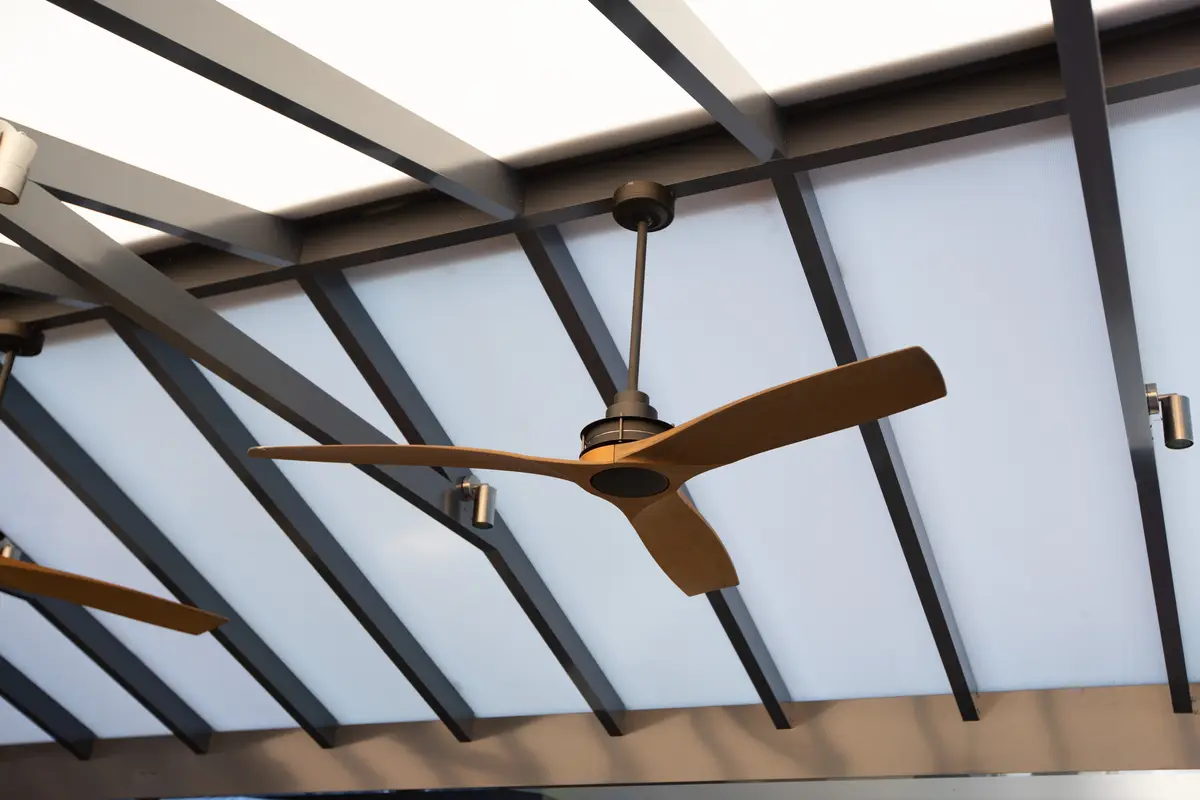 Outdoor-rated ceiling fan fitted under a pergola
