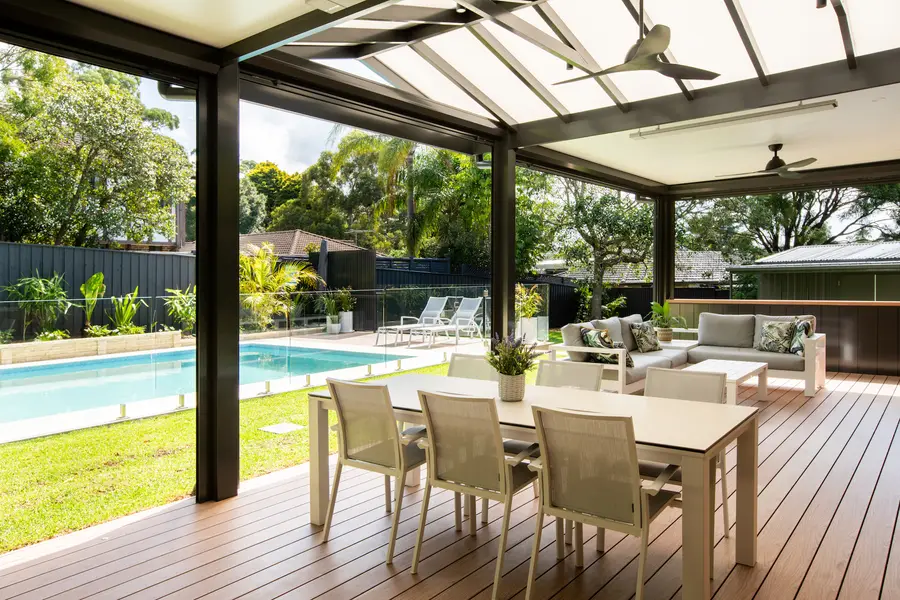 Dining and lounge settings under the combination roof, with ceiling fans and a strip heater overhead