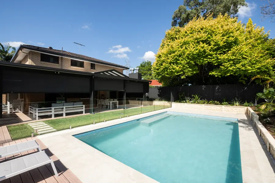 Track-guided blinds lowered across the alfresco, seen from the far side of the pool