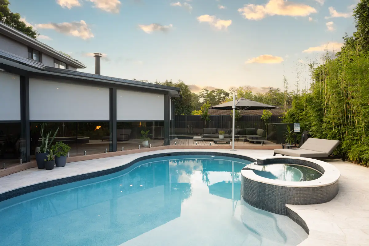 Blinds lowered the length of the alfresco at golden hour, seen across the pool, Castle Hill