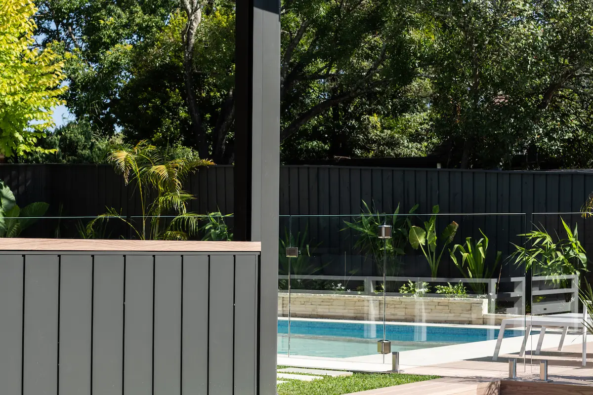 Clad wall finished with a timber-look top rail, enclosing the alfresco beside the pergola post