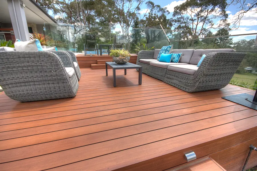 Outdoor lounge setting on the deck, looking back to the pool and house