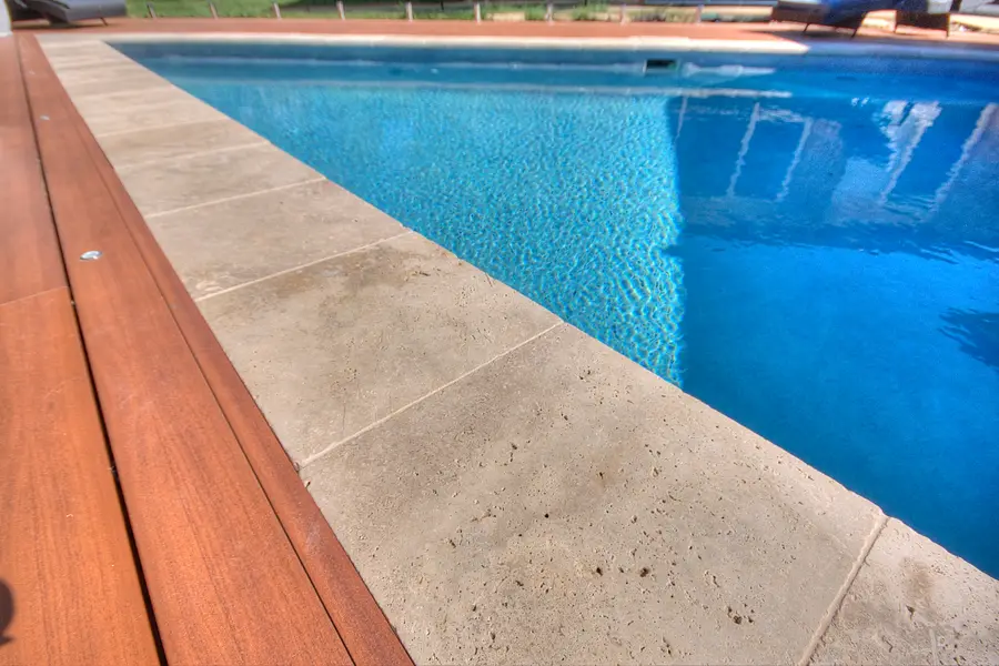 The aluminium deck turning the angled corner of the pool, in-floor lights along the edge