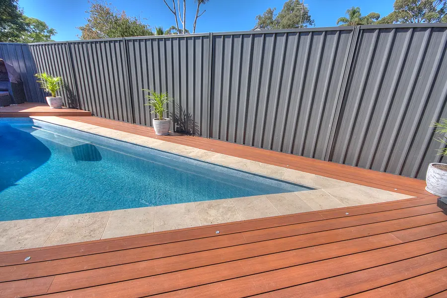 The deck against the boundary fence, following the angled pool edge