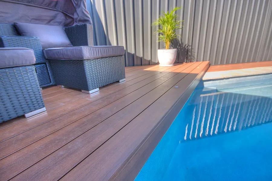 The run of deck alongside the pool, glass fencing beyond