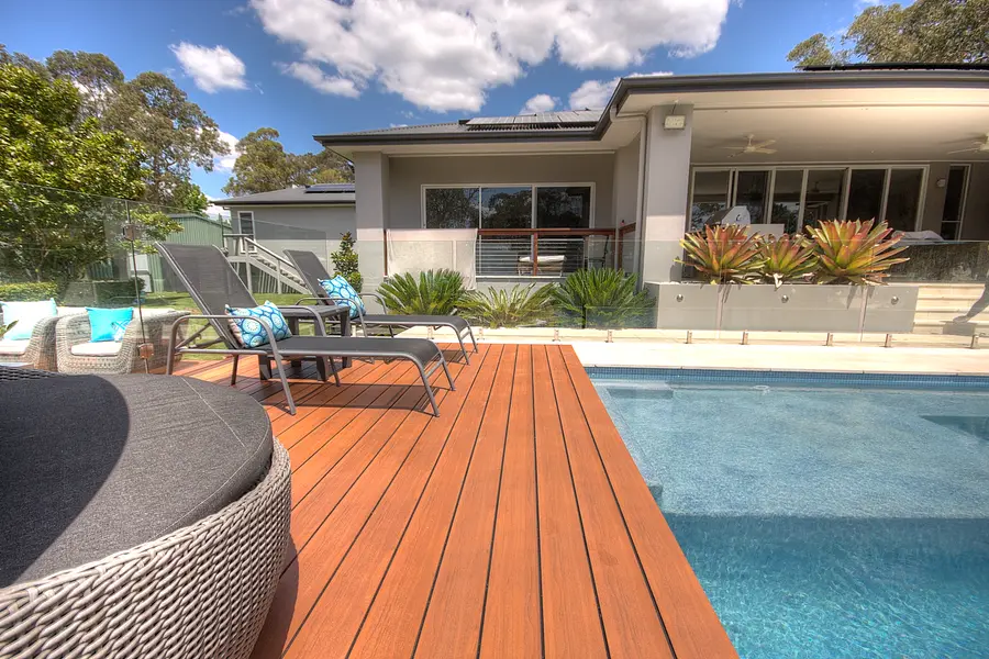 The aluminium deck running flush to the pool edge, house and bushland behind