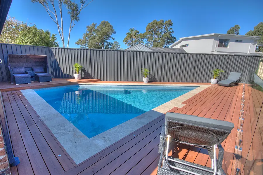 The pool and surrounding deck seen from the house end
