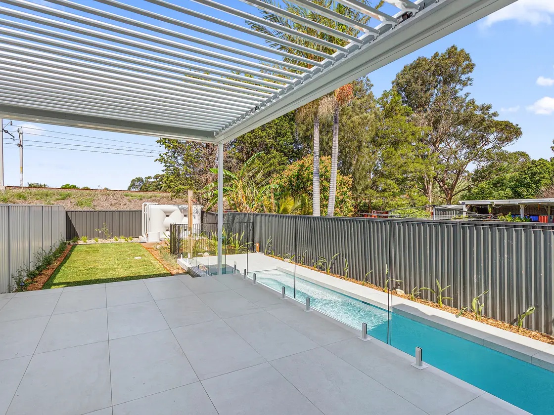 Louvred roof with the blades turned open, sky and sunlight coming straight through above a pool terrace