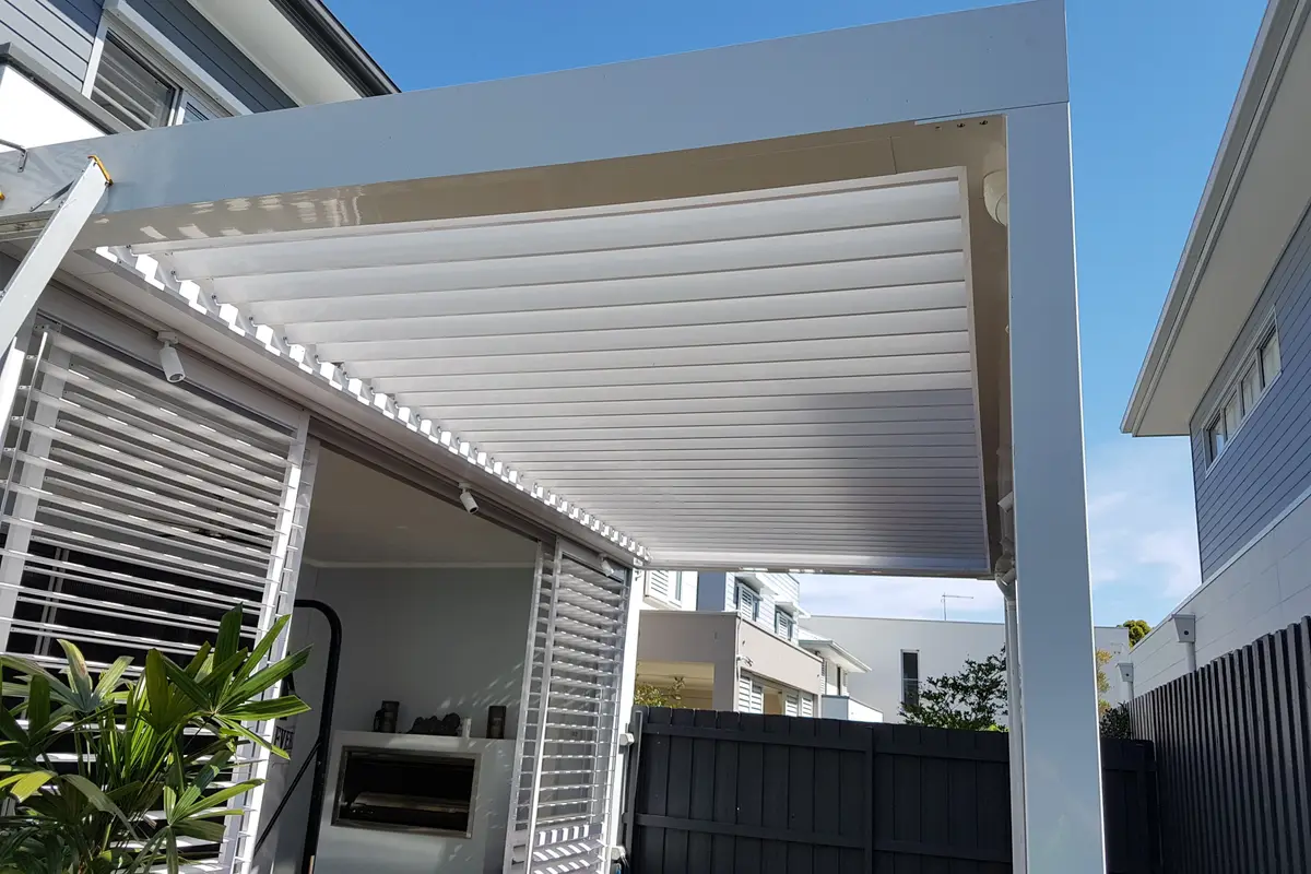 White louvred roof closed over a narrow side courtyard, with matching slat privacy screening alongside