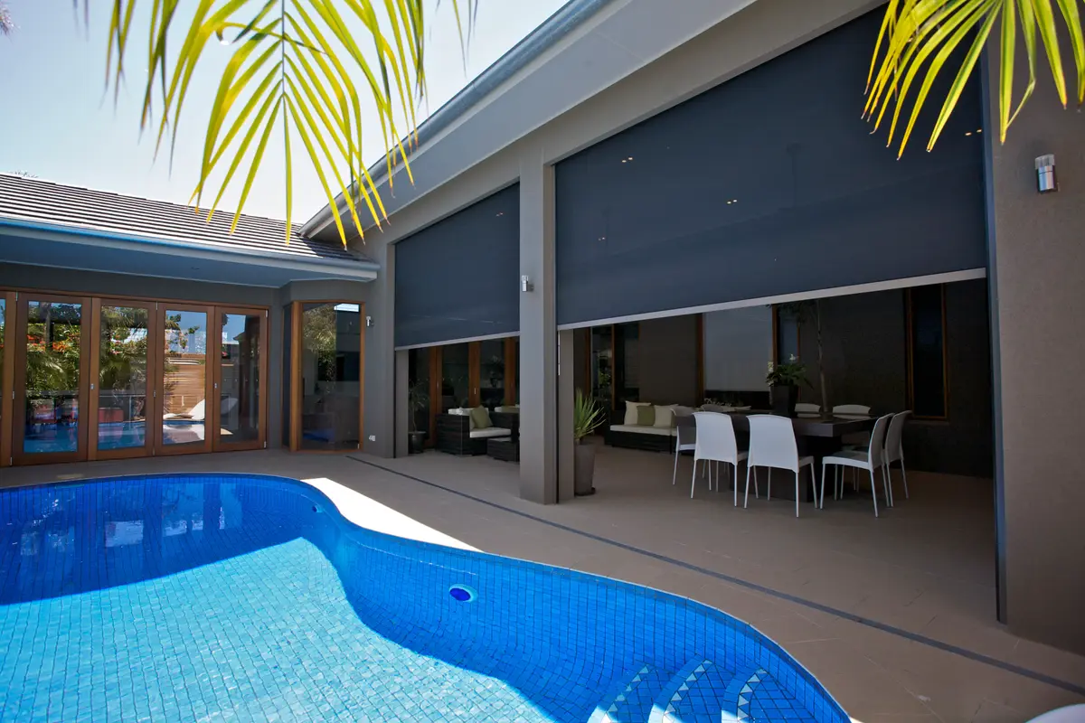 Charcoal blinds lowered across three bays of an alfresco, closing the space off from outside
