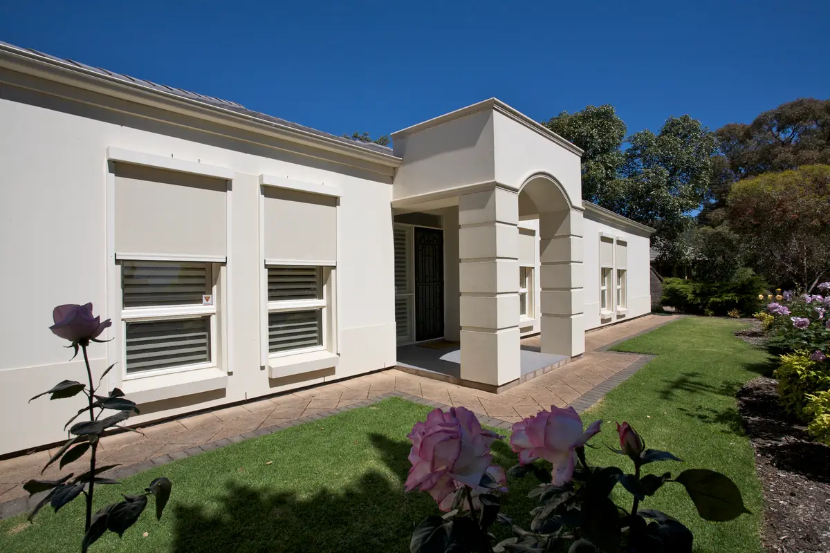 External awnings fitted above individual windows on a rendered home, lowered to shade the glass