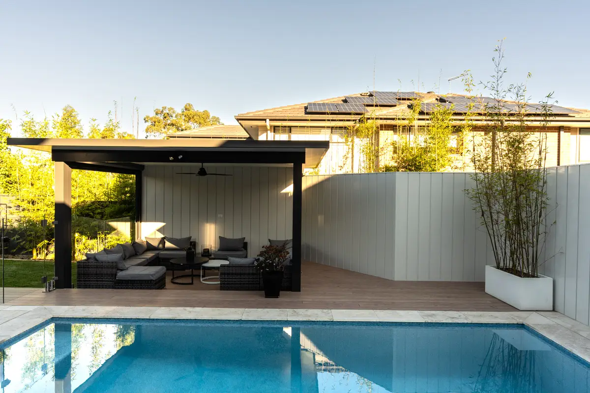 Deck running out from a freestanding pavilion to the pool coping