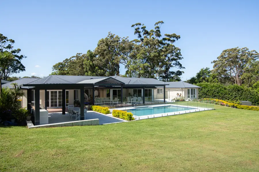 The build in its acreage setting, lawn running out to the treeline