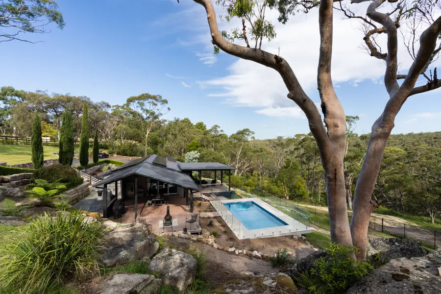 The build in its acreage setting, with lawn and bushland falling away beyond