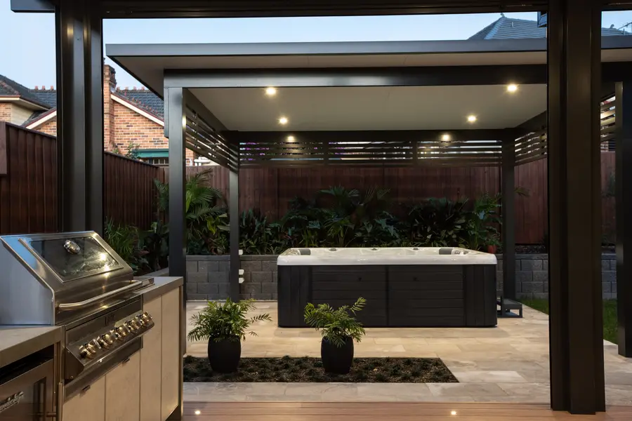 Cabana and swim spa lit by concealed downlights at dusk