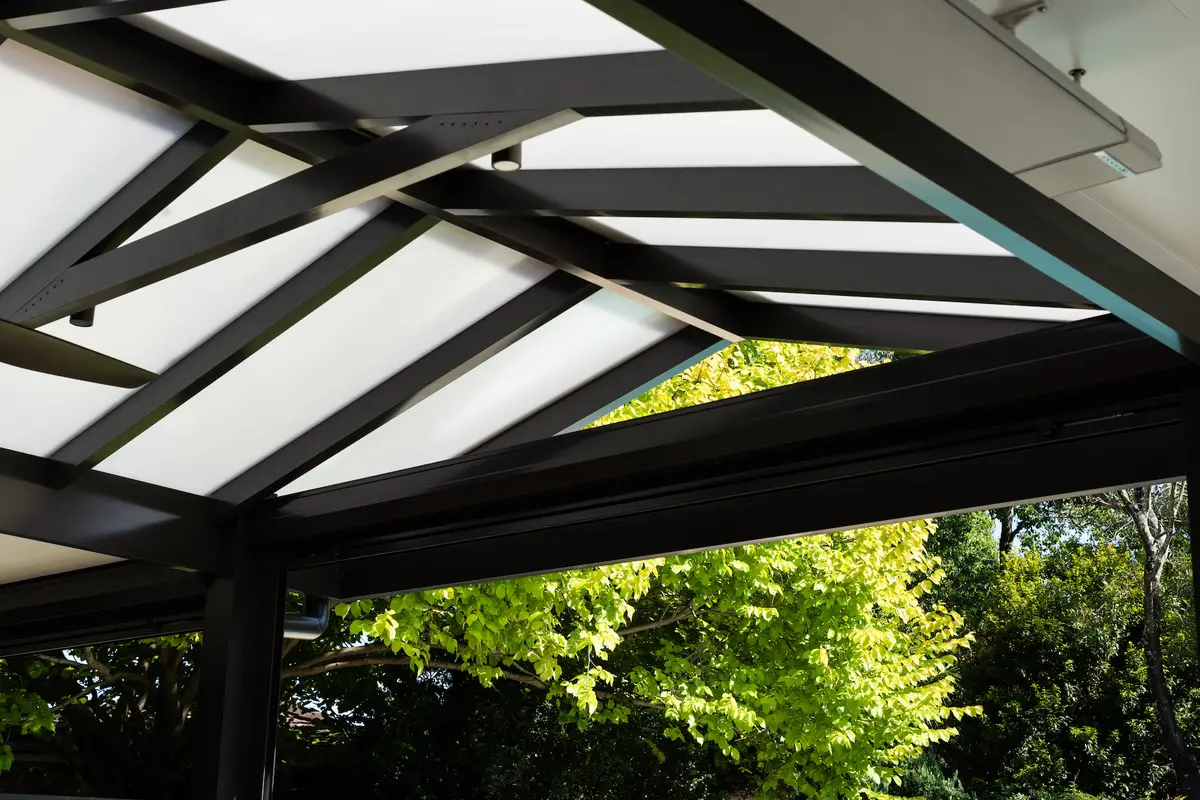Looking up into the combination roof — insulated flat panels meeting a translucent gable on black beams, Cherrybrook