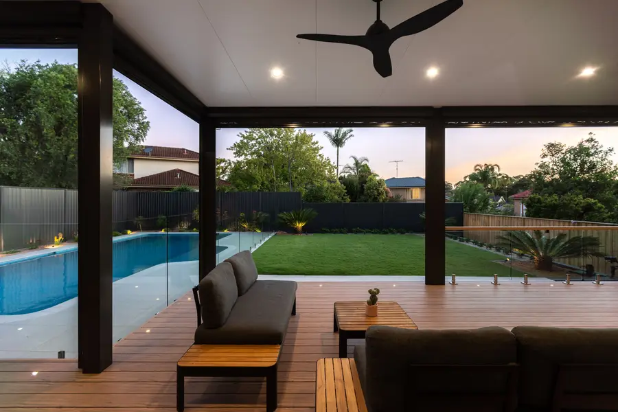 Looking out from under the pergola at dusk, in-deck lights tracing the balustrade