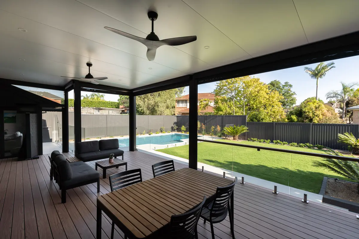 Lounge and dining under the pergola with twin ceiling fans and a glass balustrade to the lawn, Dural