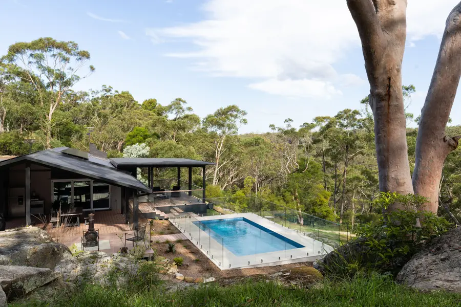 The pergola and pool seen from under a gum, with the valley beyond