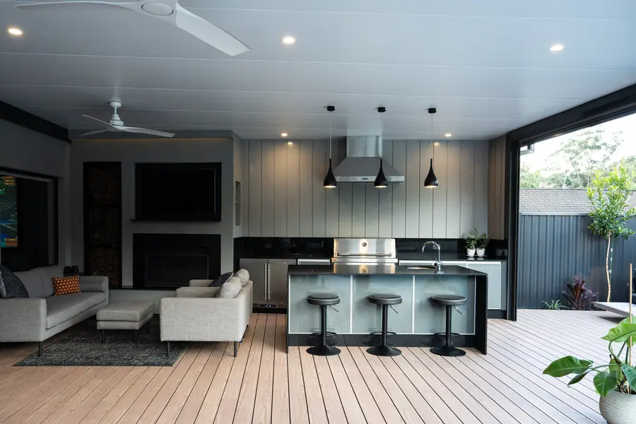 Lounge, fireplace and barbecue island sharing one covered deck