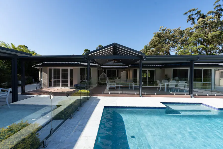 The pergola running the full width of the house, seen from across the pool