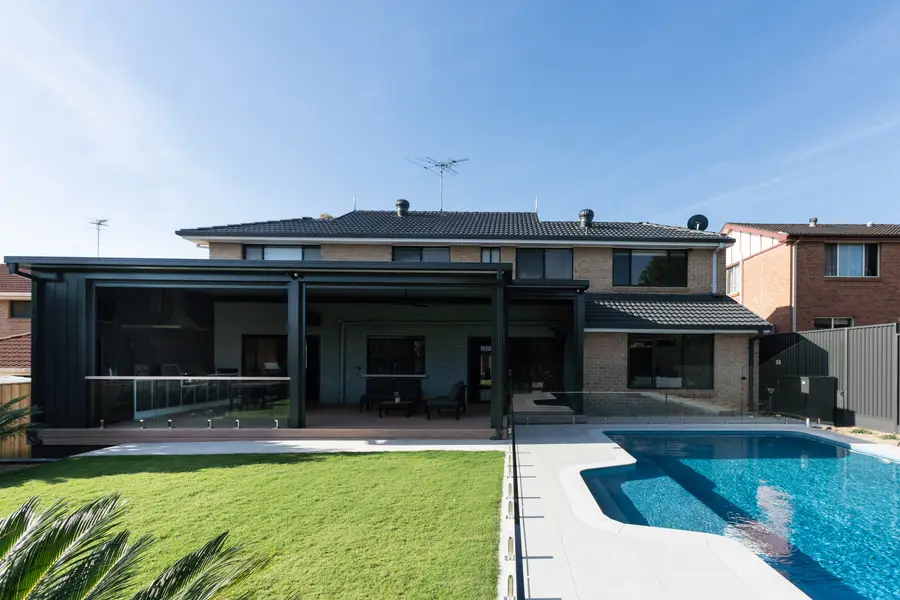 The pergola and deck across the rear of the home, seen from the lawn