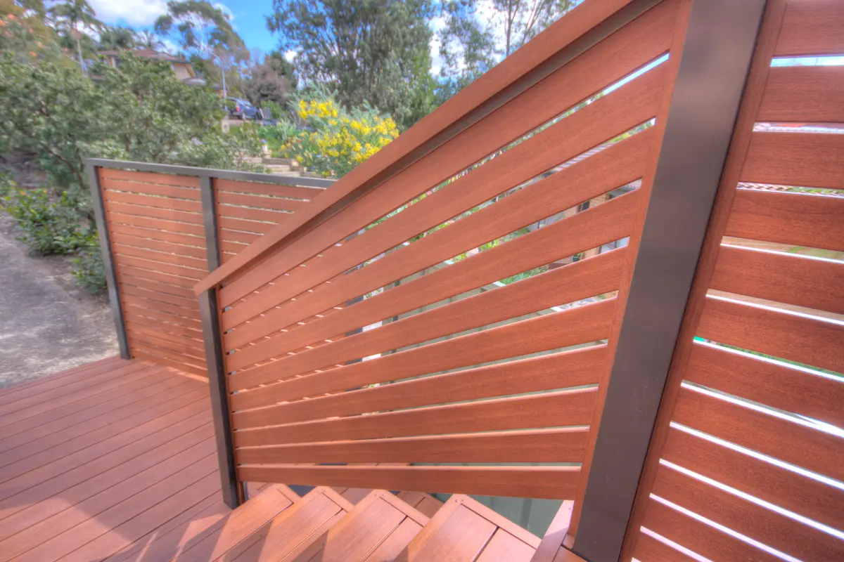 Close view of slat railing infill, showing the spacing between the timber-look aluminium slats and the charcoal posts
