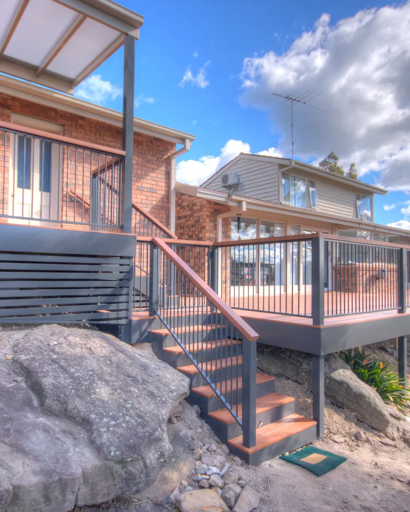 Elevated deck with aluminium baluster railing and stairs down to the garden